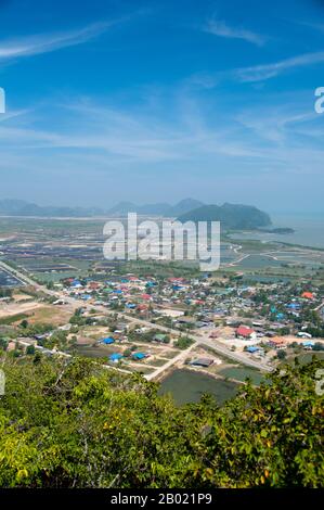 Thailand: View of Ban Khao Daeng and the surrounding countryside from the Khao Daeng viewpoint, Khao Sam Roi Yot National Park, Prachuap Khiri Khan Province.  Khao Sam Roi Yot became Thailand’s first coastal National Park in 1996. It covers an area of approximately 100 square kilometres (40 square miles) including steep limestone mountains riddled in places with caves, marshes, mangrove swamps, sandy beaches and shallow sea waters along the coast.  The name sam roi yot means ‘three hundred peaks’ and this refers directly to the many limestone outcrops and peaks that characterise the park. Stock Photo