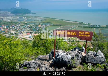 Thailand: View of Ban Khao Daeng and the surrounding countryside from the Khao Daeng viewpoint, Khao Sam Roi Yot National Park, Prachuap Khiri Khan Province.  Khao Sam Roi Yot became Thailand’s first coastal National Park in 1996. It covers an area of approximately 100 square kilometres (40 square miles) including steep limestone mountains riddled in places with caves, marshes, mangrove swamps, sandy beaches and shallow sea waters along the coast.  The name sam roi yot means ‘three hundred peaks’ and this refers directly to the many limestone outcrops and peaks that characterise the park. Stock Photo