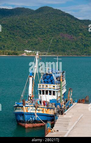 Thailand: Fishing boat at the pier, Bang Bao fishing village, Ko Chang, Trat Province.  In a country blessed with a plethora of beautiful islands, Ko Chang stands out as one of the loveliest. It’s also Thailand’s second largest island (after Phuket), but what makes it so appealing is its rugged aspect, and the way it rises suddenly from the sea, the usual lovely white sand Thai beaches, but backed by a solid hilly interior covered in wild jungle that seems to shelter the coast from the sea.  People visit Ko Chang for these pristine beaches. Stock Photo