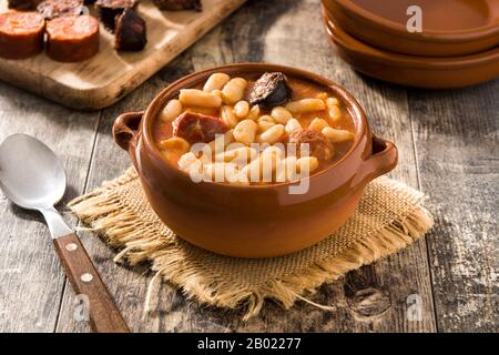 Typical Spanish fabada asturiana in crockpot on wooden table Stock Photo