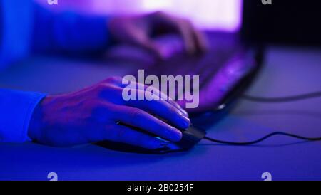 Unrecognizable Gamer Using Mouse Playing Computer Game Indoor, Cropped, Closeup Stock Photo