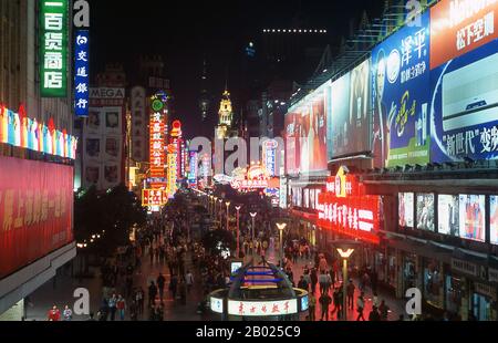 China: Neon lights on Nanjing Lu, Shanghai’s exclusive shopping avenue, (Walking Street), Shanghai.  Shanghai began life as a fishing village, and later as a port receiving goods carried down the Yangzi River. From 1842 onwards, in the aftermath of the first Opium War, the British opened a ‘concession’ in Shanghai where drug dealers and other traders could operate undisturbed. French, Italians, Germans, Americans and Japanese all followed. By the 1920s and 1930s, Shanghai was a boom town and an international byword for dissipation. Stock Photo