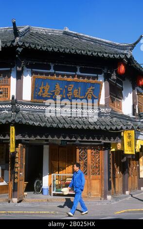 China: A man walks by a tea house on Fangbang Lu in Nanshi or the Old Town area, Shanghai. Shanghai began life as a fishing village, and later as a port receiving goods carried down the Yangzi River. From 1842 onwards, in the aftermath of the first Opium War, the British opened a ‘concession’ in Shanghai where drug dealers and other traders could operate undisturbed. French, Italians, Germans, Americans and Japanese all followed. By the 1920s and 1930s, Shanghai was a boom town and an international byword for dissipation. Stock Photo