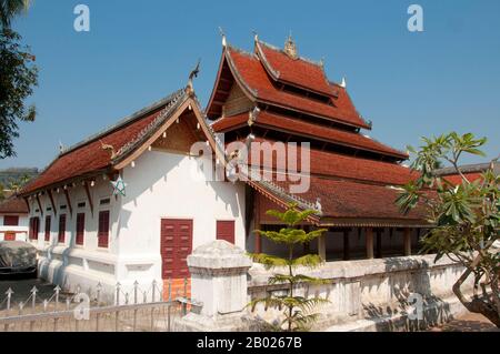 Wat Mai Suwannaphumaham dates from the early 19th century. The temple was once the residence of the Sangkhalat, the supreme patriarch of Buddhism in Laos.  The sim (ordination hall) is wooden, with a five-tiered roof in classic Luang Prabang style. The main attraction of the sim is the gilded walls of the front veranda, the designs of which recount scenes from the Ramayana and the Buddha’s penultimate incarnation (Vessantara Jataka).  For the first half of the 20th century the Phra Bang (Royal Buddha image in the Dispelling Fear mudra) was housed inside the sim, and it is still put on display Stock Photo