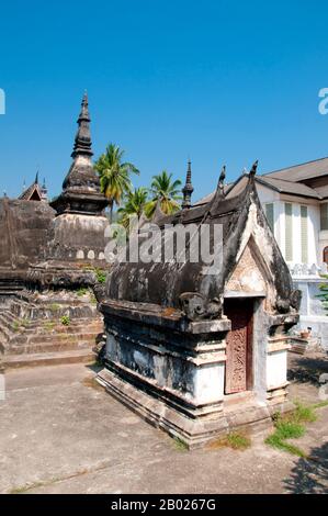 Wat Mai Suwannaphumaham dates from the early 19th century. The temple was once the residence of the Sangkhalat, the supreme patriarch of Buddhism in Laos.  The sim (ordination hall) is wooden, with a five-tiered roof in classic Luang Prabang style. The main attraction of the sim is the gilded walls of the front veranda, the designs of which recount scenes from the Ramayana and the Buddha’s penultimate incarnation (Vessantara Jataka).  For the first half of the 20th century the Phra Bang (Royal Buddha image in the Dispelling Fear mudra) was housed inside the sim, and it is still put on display Stock Photo