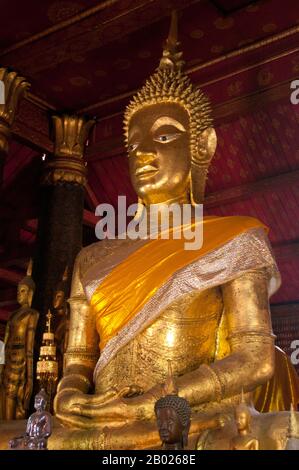 Wat Mai Suwannaphumaham dates from the early 19th century. The temple was once the residence of the Sangkhalat, the supreme patriarch of Buddhism in Laos.  The sim (ordination hall) is wooden, with a five-tiered roof in classic Luang Prabang style. The main attraction of the sim is the gilded walls of the front veranda, the designs of which recount scenes from the Ramayana and the Buddha’s penultimate incarnation (Vessantara Jataka).  For the first half of the 20th century the Phra Bang (Royal Buddha image in the Dispelling Fear mudra) was housed inside the sim, and it is still put on display Stock Photo