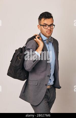 a spectacular young businessman in suit with big bag Stock Photo