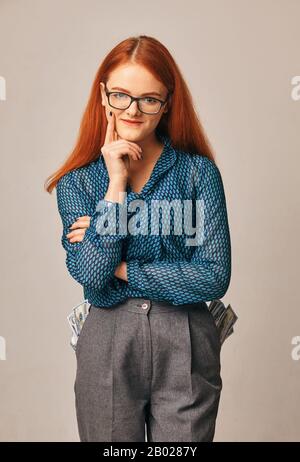young smiling businesswoman. bills stick out from her pockets Stock Photo