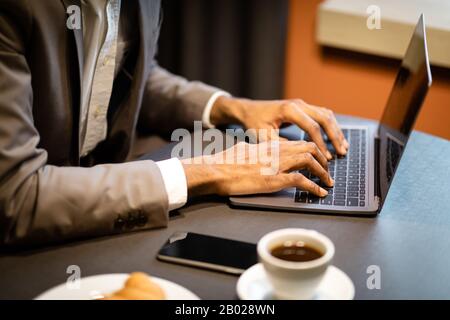 Cropped image of afro guy using laptop computer Stock Photo