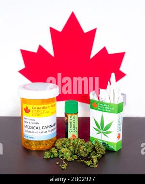 Cannabis in Canada. Medical cannabis, cannabis oil, buds, and a package of cannabis cigarettes on a table, with a Canadian maple leaf behind. Stock Photo