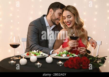 Passionate couple dining in restaurant, drinking wine and having romantic moments Stock Photo