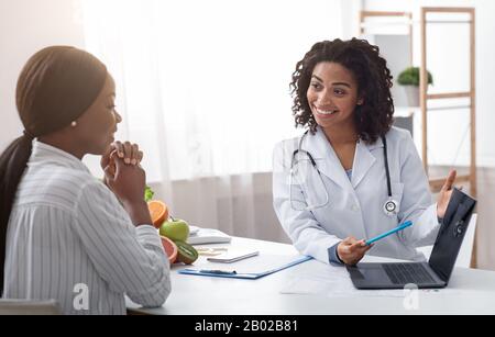 Dietologist using laptop in office, making patient's anamnesis Stock Photo