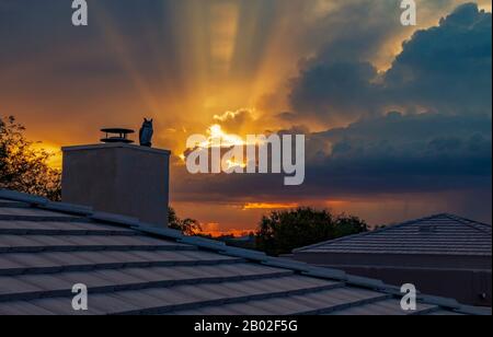 Epric sun rays and beams shining through clouds over a roof in the Arizoma Desert at sunset near Scottsdale, Arizona. Stock Photo