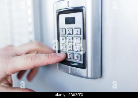 Man hand pressing the security code combination to unlock the door Stock Photo