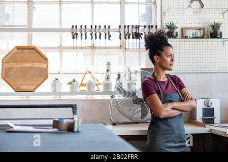 Young female artisan standing in her picture framing shop Stock Photo