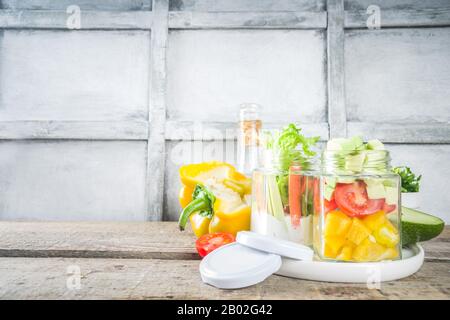 Healthy take-away lunch jar. Vegan vegetable salad in glass jars, with sliced fresh vegetables. Detox, raw eating and zero waste lunch concept Stock Photo