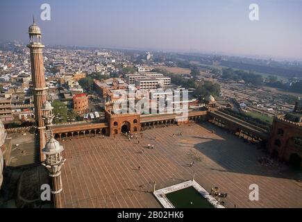 Delhi’s great Masjid-i Jahān-Numā, commonly known as the Jama Masjid or Friday Mosque is the largest in the country, with a courtyard capable of holding 25,000 worshippers. It was built in 1644, the last in a series of magnificent architectural achievements by Shah Jahan, the Moghul emperor who also built the Taj Mahal and the Red Fort.  The elaborately decorated mosque has three great gateways, four towers and two 40m (131ft) high minarets constructed of alternating bands of red sandstone and white marble. Non-Muslims are welcome to visit the mosque but preferably not during prayer times; rev Stock Photo