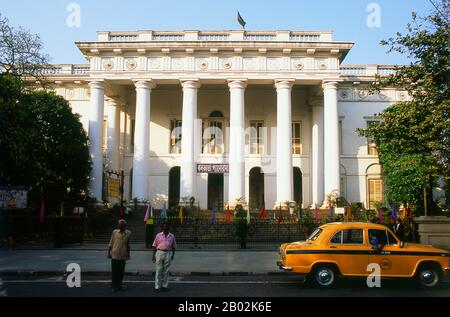 Kolkata's Roman Doric style Town Hall was built in 1813 by architect Major General John Garstin (1756 - 1820). It was used originally as a social venue for Europeans living in the town.  The tax records of Mughal Emperor Akbar (1584–1598) as well as the work of a 15th century Bengali poet, Bipradaas, both mention a settlement named Kalikata (thought to mean ‘Steps of Kali’ for the Hindu goddess Kali) from which the name Calcutta is believed to derive.  In 1690 Job Charnock, an agent of the East India Company, founded the first modern settlement in this location. In 1698 the company purchased t Stock Photo