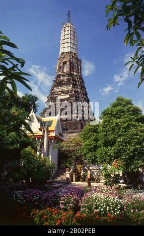 A prang is a tall tower-like spire, usually richly carved. They were a common shrine element of Hindu and Buddhist architecture in the Khmer Empire. They were later adapted by Buddhist builders in Thailand, especially during the Ayutthaya Kingdom (1350–1767) and Rattanakosin Kingdom (1782-1932). In Thailand it appears only with the most important Buddhist temples.  Wat Chakkrawat is famous for its live crocodiles and also a small grotto containing what is called a Buddha shadow. Visitors press gold leaf on the shadow shape. Stock Photo