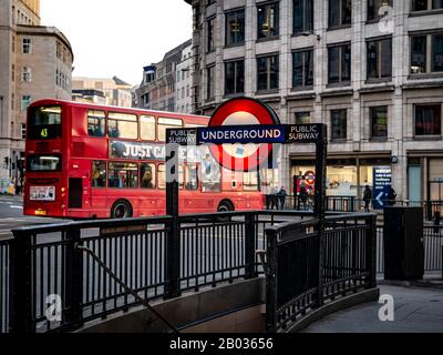 Red London Bus passing Monument underground station Stock Photo