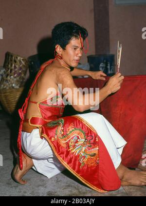 Thailand: A possessed spirit medium or ma song, The Nine Emperor Gods Festival, Chao Mae Thapthim Shrine (Taoist Chinese joss house), Wang Burapha, Bangkok (1989). The Nine Emperor Gods Festival is a nine-day Taoist celebration beginning on the eve of 9th lunar month of the Chinese calendar, which is observed primarily in Southeast Asian countries like Myanmar, Singapore, Malaysia, and Thailand. Stock Photo