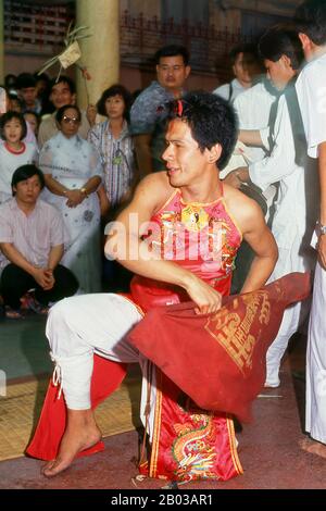 Thailand: A possessed spirit medium or ma song, The Nine Emperor Gods Festival, Chao Mae Thapthim Shrine (Taoist Chinese joss house), Wang Burapha, Bangkok (1989). The Nine Emperor Gods Festival is a nine-day Taoist celebration beginning on the eve of 9th lunar month of the Chinese calendar, which is observed primarily in Southeast Asian countries like Myanmar, Singapore, Malaysia, and Thailand. Stock Photo