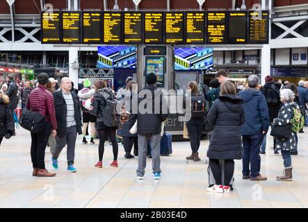 Train passengers looking at the departure board, Paddington train Station, Paddington London UK Stock Photo