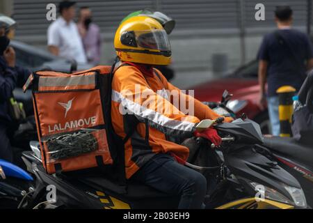 Manila, Philippines - February, 3, 2020: Delivery motorcyclist in traffic on the roads of Makati Stock Photo