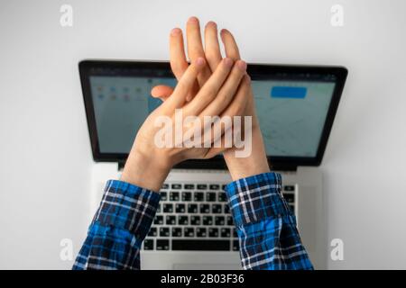 a top view of person hands close cover or block the laptop webcam, being afraid of spy hack the camera Stock Photo