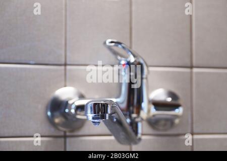 A tap in the kitchen. Water leaking from the tap with a damaged gasket. Stock Photo