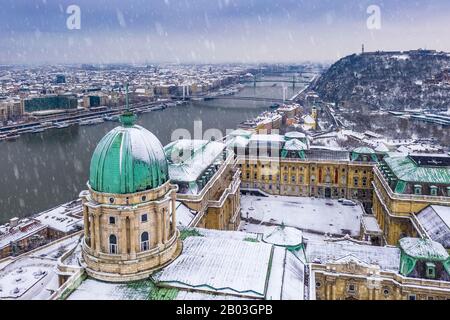 Budapest, Hungary - Aerial view of the snowy Buda Castle Royal Palace with Statue of Liberty, Elisabeth and Liberty Bridge and Gellert Hill at winter Stock Photo