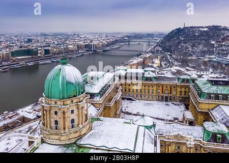 Budapest, Hungary - Aerial view of the snowy Buda Castle Royal Palace with Statue of Liberty, Elisabeth and Liberty Bridge and Gellert Hill at winter Stock Photo