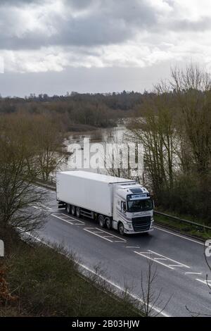Looking down on a white HGV travelling west on A5 in Shropshire over a flooded River Severn which has burst its banks and flooded fields close by. Stock Photo