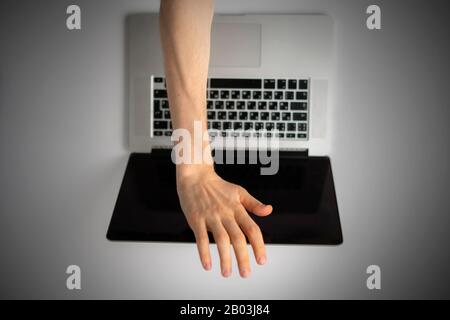 a top view of person hands close cover or block the laptop webcam, being afraid of spy hack the camera Stock Photo