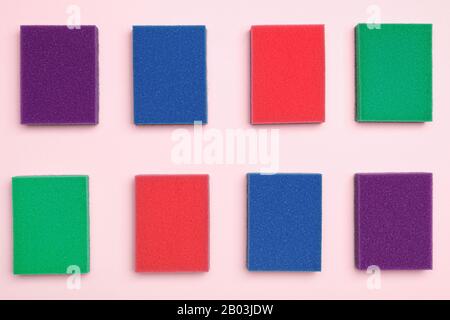 Multi-colored foam sponges for cleaning and washing dishes on a pink background. Top view flat lay. Stock Photo