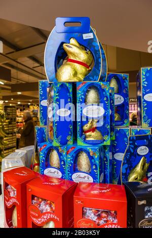 Display of a colourful stack of Lindt Lindor chocolate Easter eggs and gold bunny eggs stacked up in a garden centre in south-east England Stock Photo