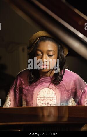 British female rapper Little Simz (real name Simbiatu Abisola Abiola Ajikawo) performing at the piano during the video shoot for Leave It As That. Stock Photo