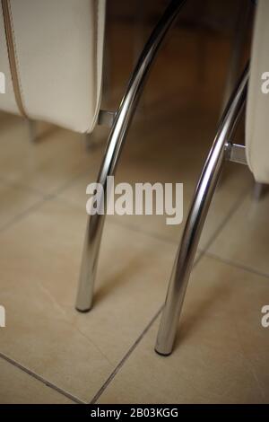 Modern kitchen leather chairs with chrome legs on the tiled floor Stock Photo