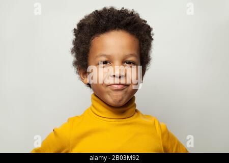 Funny black child boy grimacing on white background Stock Photo