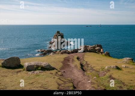 Views over the Celtic Sea from Land's End, Cornwall, across the dramatic landscape, skerries and Longships Lighthouse in the distance. Stock Photo