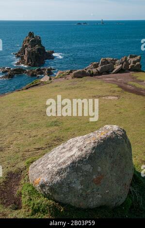 Views over the Celtic Sea from Land's End, Cornwall, across the dramatic landscape, skerries and Longships Lighthouse in the distance. Stock Photo