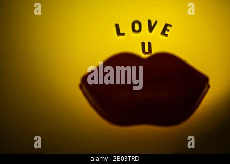 love you sign on yellow background with  big lips Stock Photo