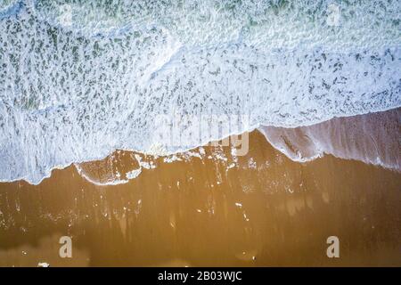 Waves breaking on beach aerial overhead Stock Photo