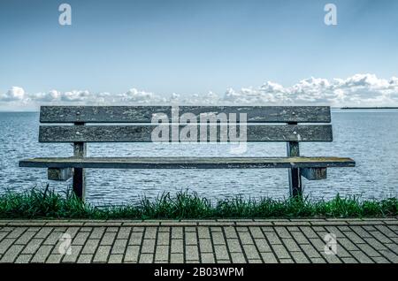 Bench on the shore of a lake or a sea. Stock Photo