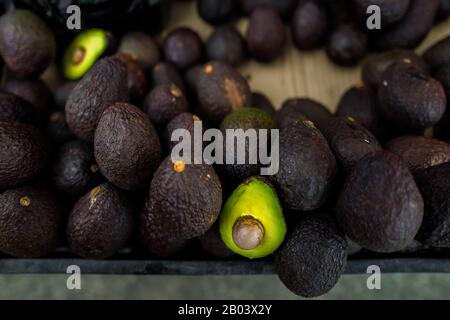Ripe, black-purplish Hass avocados are seen offered for sale in the street of Medellín, Antioquia department, Colombia. Stock Photo