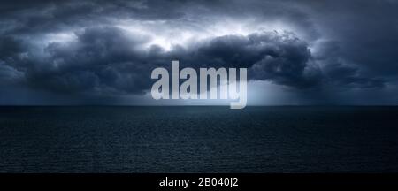 dark and dramatic stormy clouds over sea Stock Photo
