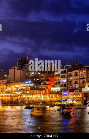 Paceville district of St Julian town, Malta, popular nightlife hotspot, view from Spinola Bay at night Stock Photo