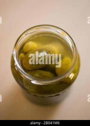 Pickled cucumbers in open jar close-up on the table Stock Photo