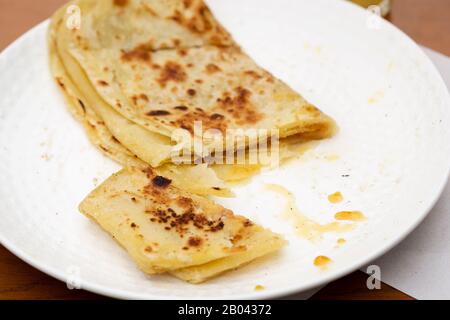 Moroccan Msemen with honey on plate. Square flatbread  served cafe, Marrakech, Morocco Stock Photo