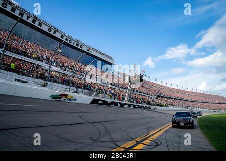 U.S President Donald Trump and First Lady Melania Trump ride in the presidential limousine as they take a pace lap ahead of the start of the NASCAR Daytona 500 auto race at Daytona International Speedway February 16, 2020 in Daytona Beach, Florida. In addition to the pace lap, Trump served as the official starter of the auto race. Stock Photo